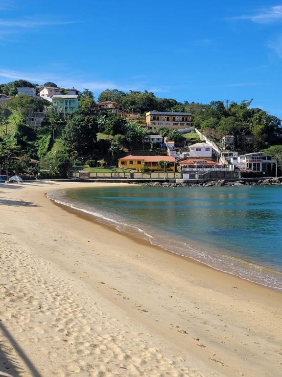 a view of a beach with the ocean and buildings at Paraíso Ibicui in Mangaratiba