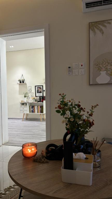 a table with a candle and a vase with flowers at الغزال in Al Hofuf
