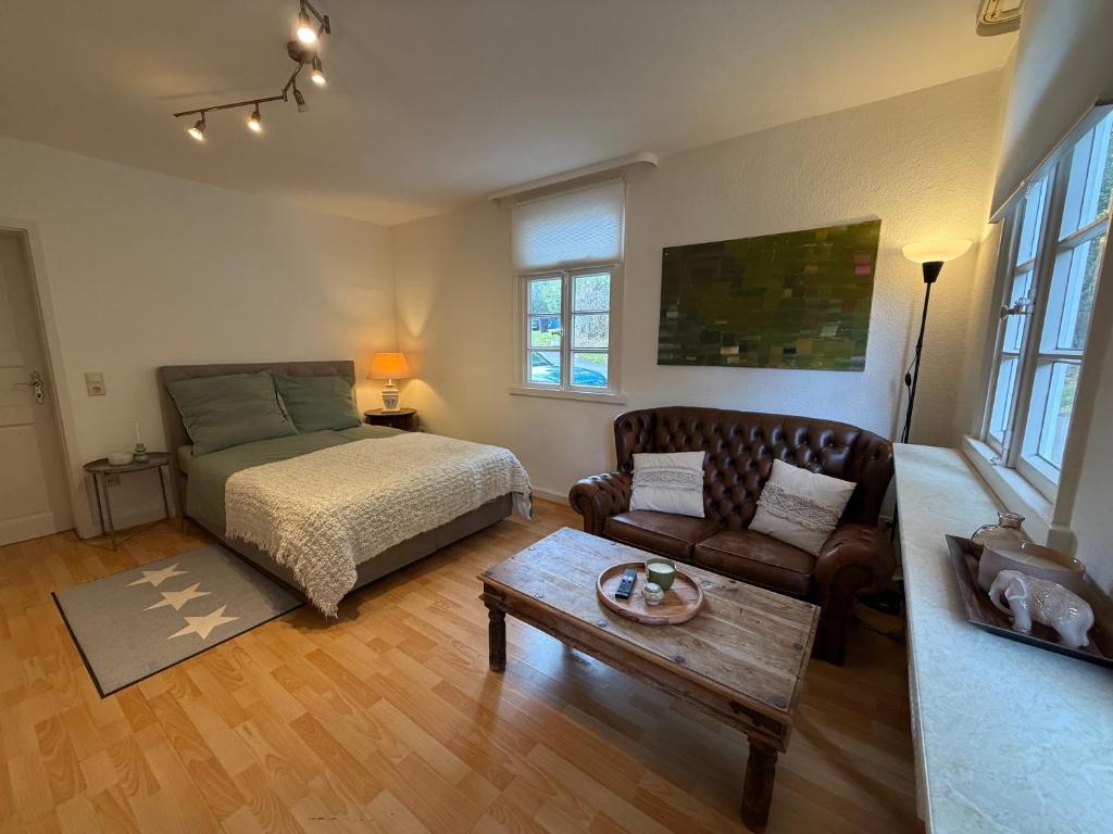 ヴェルメルスキルヒェにあるFerienwohnung Altes Gut Kenkhausenのベッドとソファとテーブルのある寝室