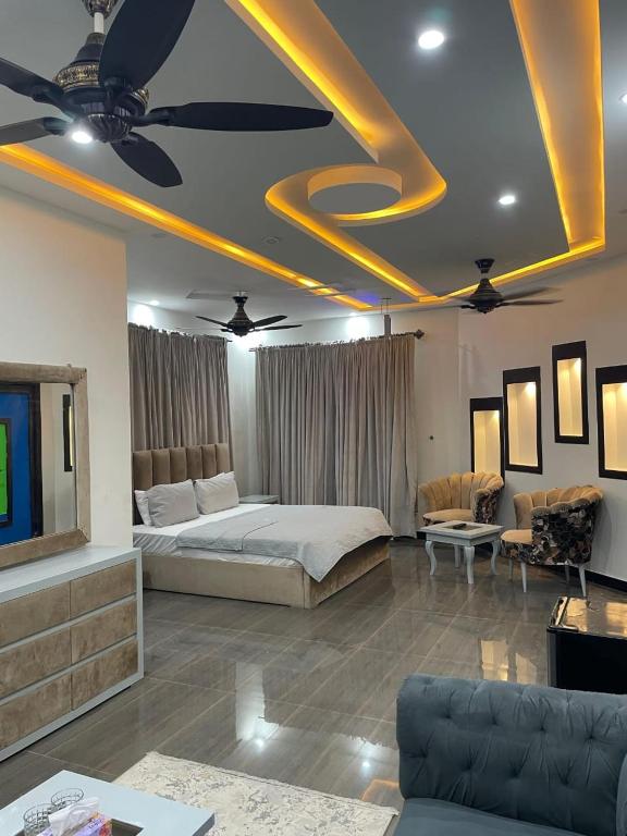 Un dormitorio con una cama y una sala de estar. en The Bless inn Hotel, en Islamabad