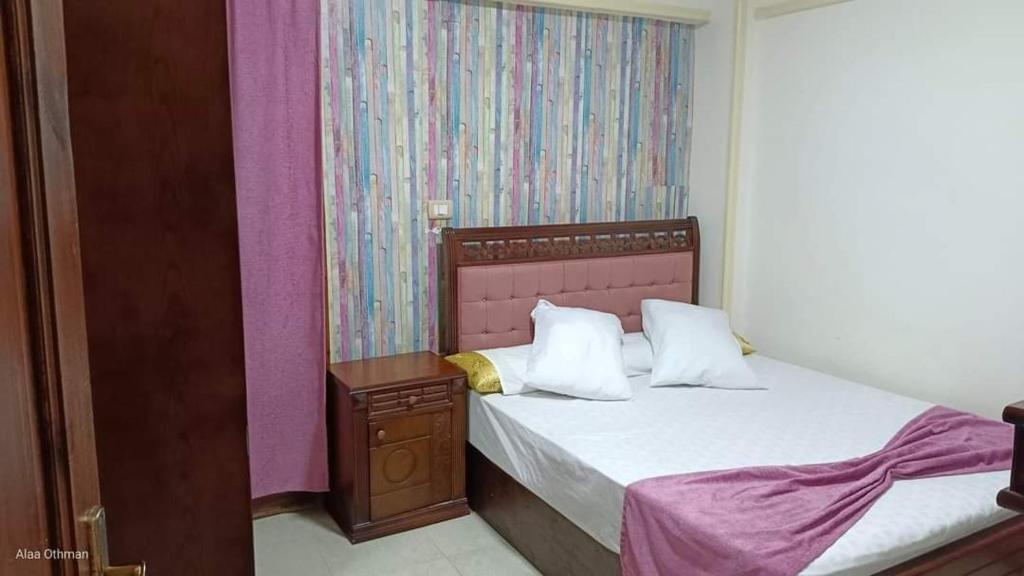 a bedroom with a bed with white sheets and pillows at شاليهات مراسي للتنمية السياحيه in Marsa Matruh