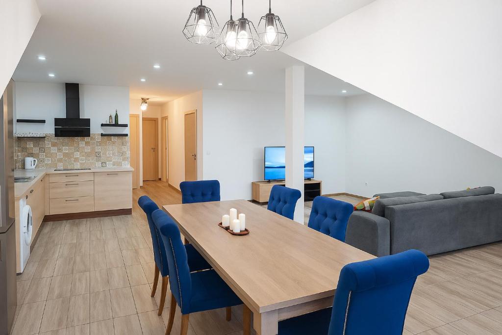 a dining room and living room with a table and blue chairs at Apartament 45 in Olszewnica Nowa
