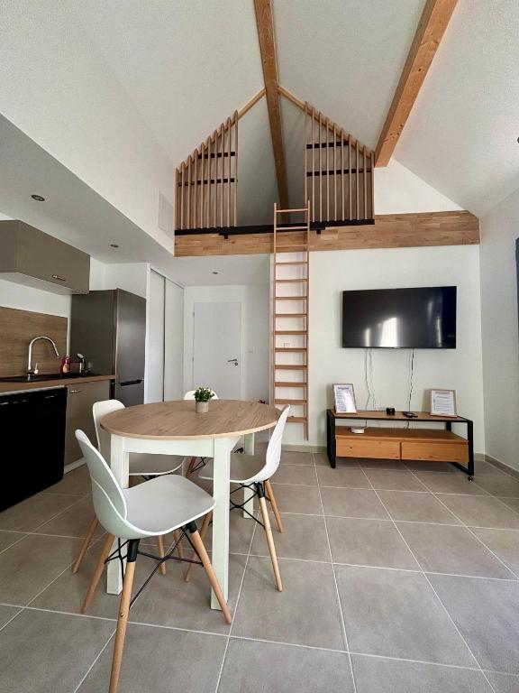 a living room with a table and a loft at Maison individuelle meublée in Chaignay
