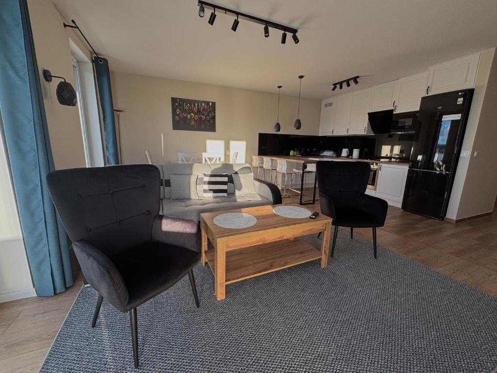 Una sala de estar con un sofá y sillas y una mesa. en Apartament Płocka 2, en Gdansk