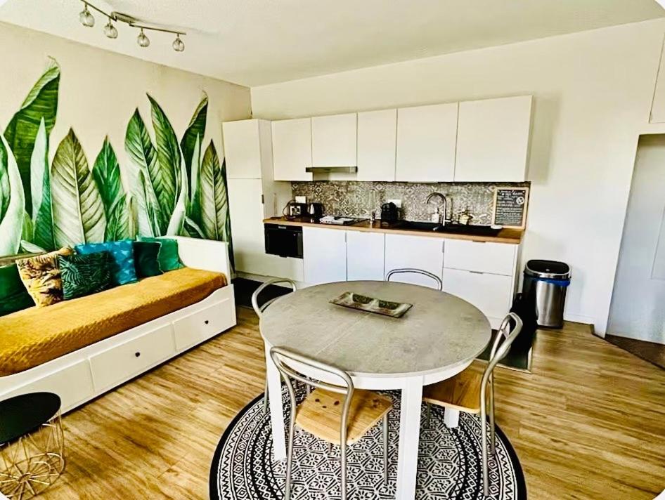 a kitchen and a living room with a table and a couch at T2 Cozy au Centre 4 Personnes RochExpo Train Express Annecy Genève Evian in La Roche-sur-Foron
