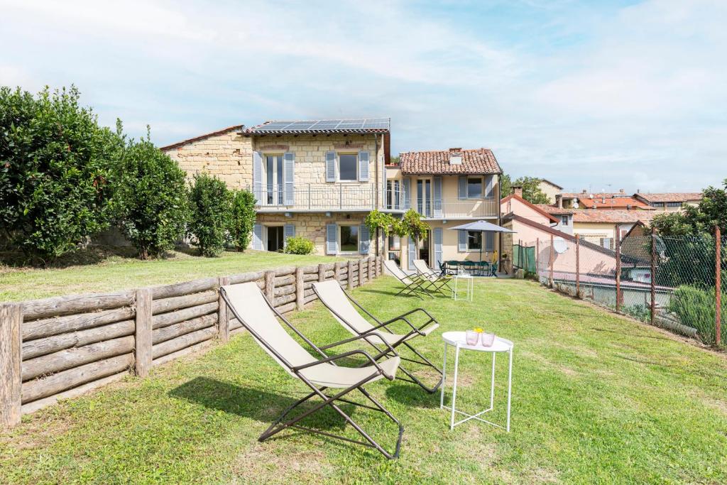 un patio con 2 sillas y una mesa frente a una casa en Cozy Court - Relax in Monferrato, en Grazzano Badoglio