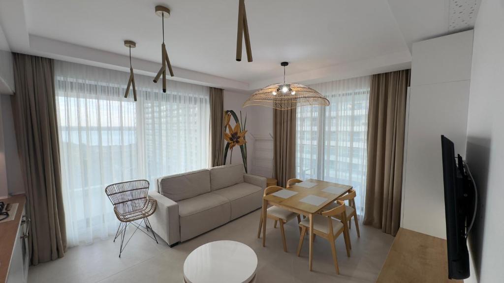 ein Wohnzimmer mit Sofa und Tisch in der Unterkunft Velora Apartments in Năvodari