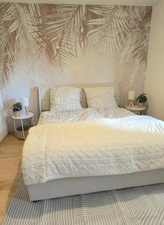 a bedroom with a large bed with a wall mural at FeWo Oahu in Meisenheim