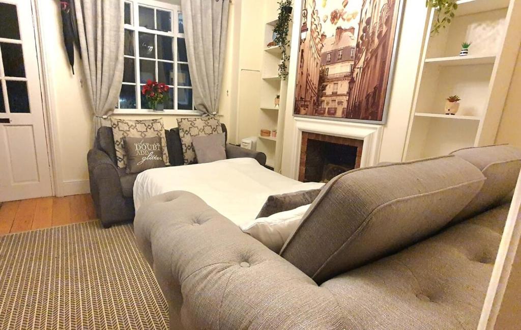 a living room with a bed and a couch at Windsor Castle amazing Cottage in Windsor