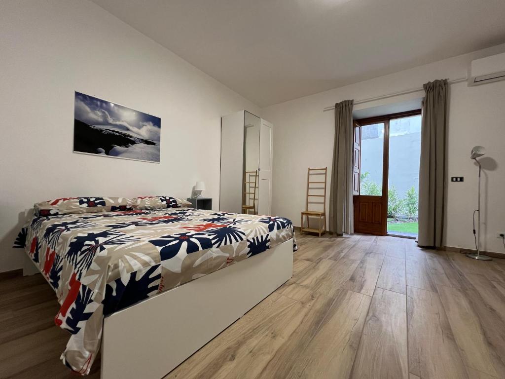 una camera da letto con un letto e una grande finestra di Casale Don Minzoni a Misterbianco