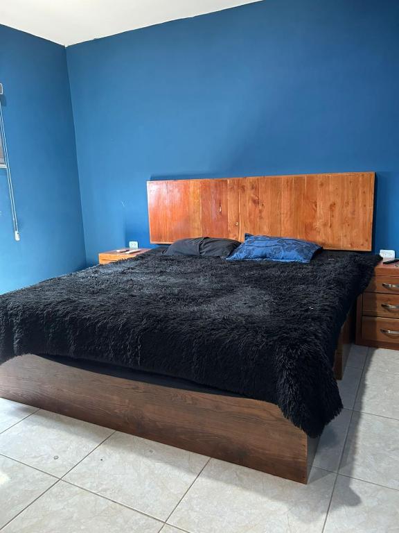 Un dormitorio con una cama grande con cabecero de madera. en Casa completa, en Mazatlán