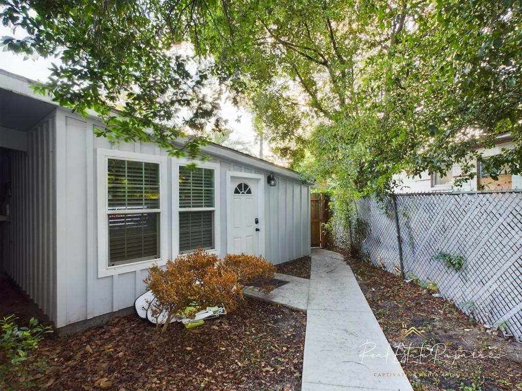 a white house with a fence and a tree at The Perfect One Night Stay in Jacksonville