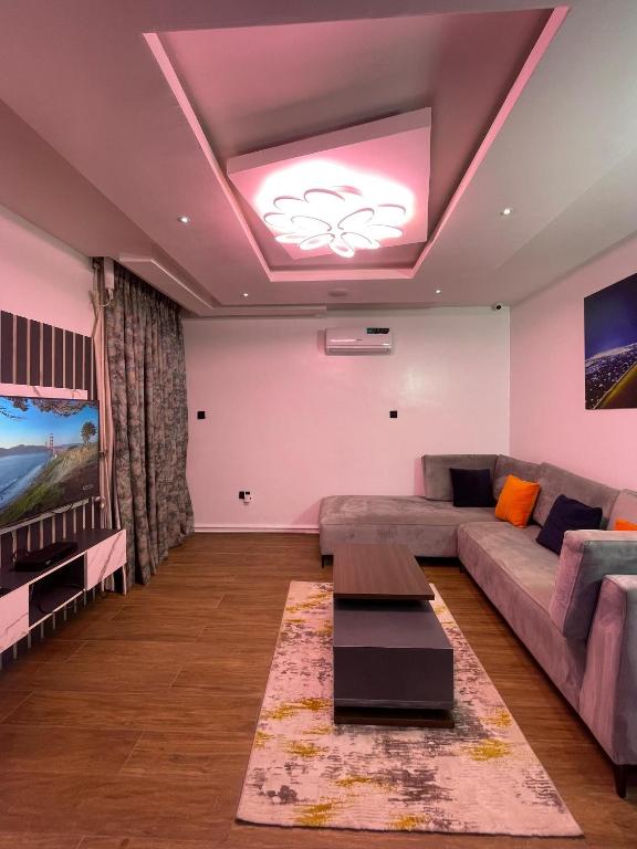 a living room with a couch and a table at The Elegans Apartments in Rubuchi