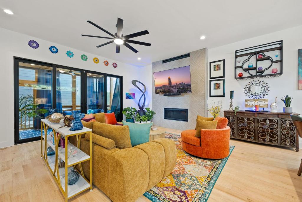 ein Wohnzimmer mit orangefarbenen Stühlen und einem Deckenventilator in der Unterkunft Luxury Home 4BR 4BA City Views HotTub GameRoom in Atlanta