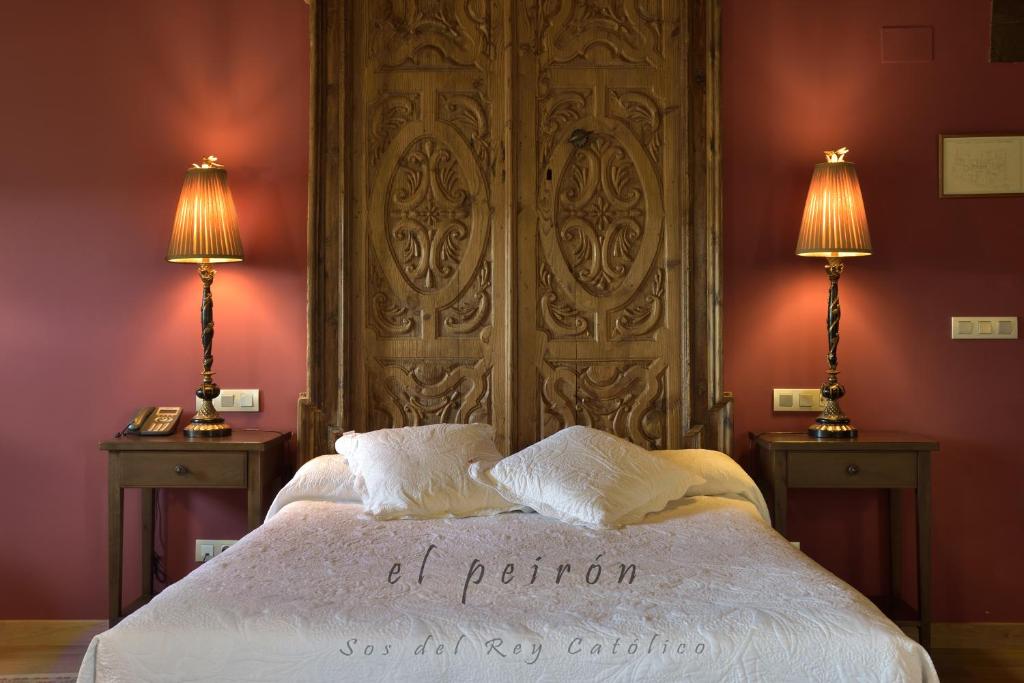 a bedroom with a large bed with two lamps at El Peiron in Sos del Rey Católico