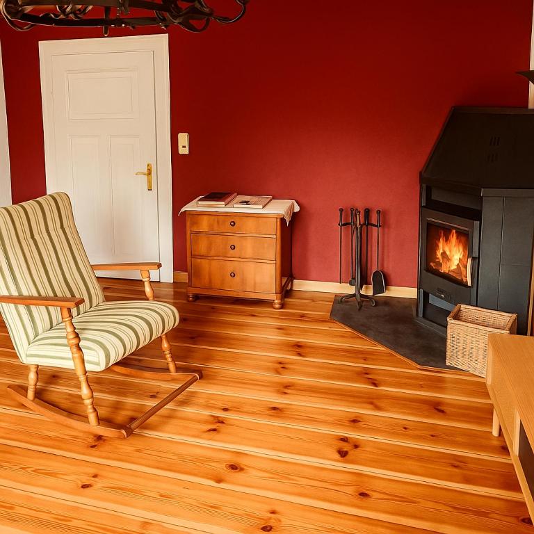 a living room with a chair and a fireplace at Ferienhaus Schorfheide Kamin Sauna Naturgarten nahe Seen & Wildpark in Schorfheide
