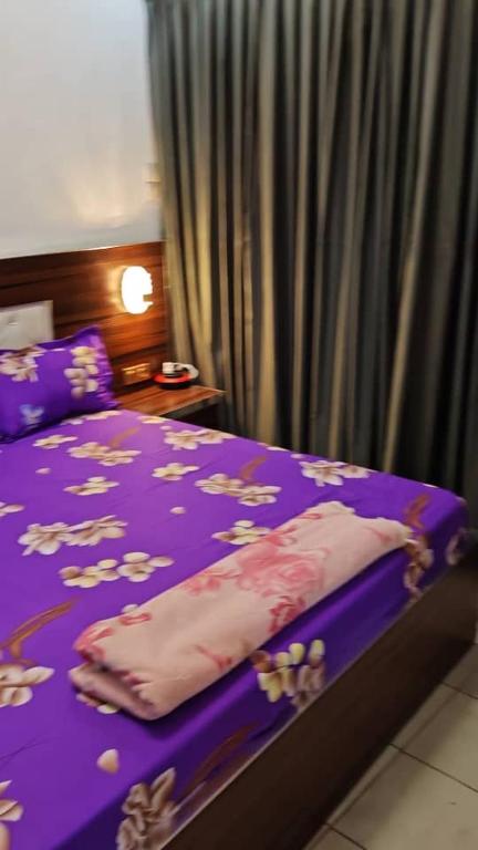 a purple bed with a blanket on top of it at Oumou et Aicha in Dakar
