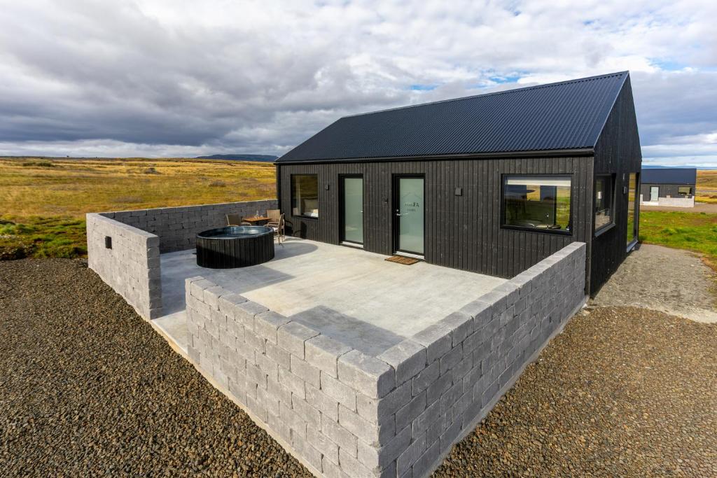 TorfastaðirTorfa Lodge - Boutique Cabin的一座带石墙的黑色房子