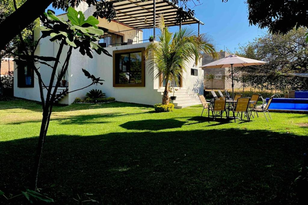 a yard with a table and chairs and an umbrella at Casa GOGA in Oaxtepec