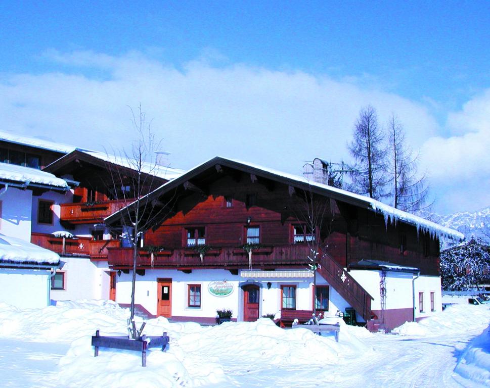 オーベルンドルフ・イン・チロルにあるKaiserappartements Müllnerhofの雪の積もった大きな建物
