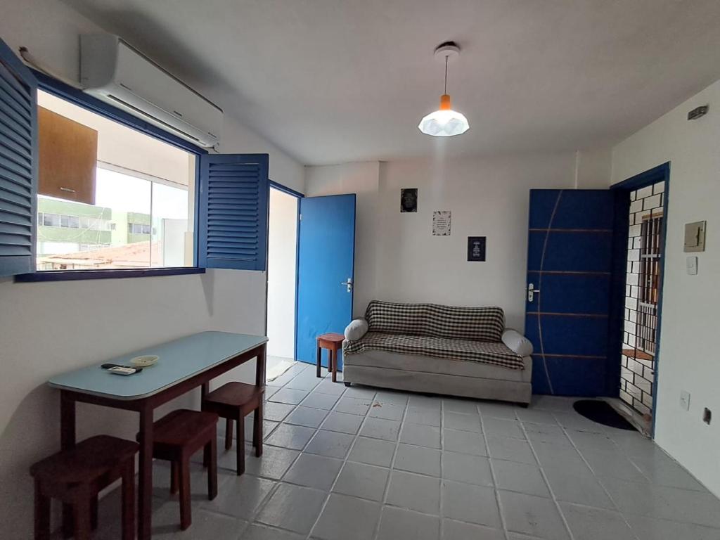 een woonkamer met een bank en een tafel bij Apartamento completo Jacumã in Conde