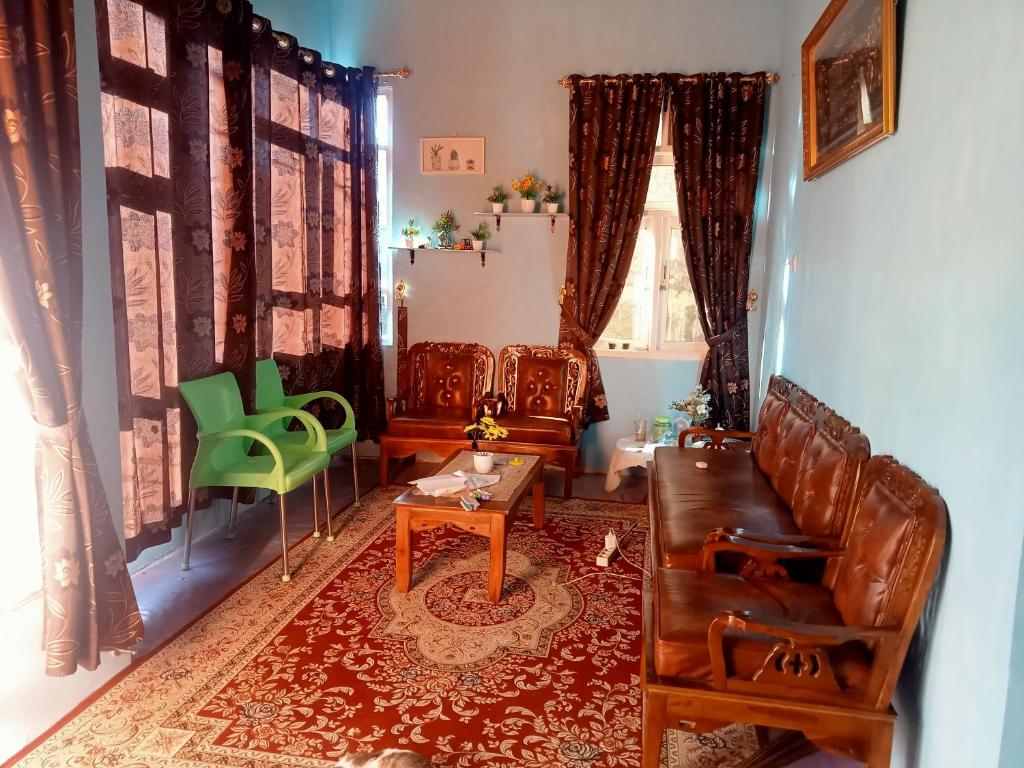 a living room with chairs and a couch and a table at Chinta Khanza 