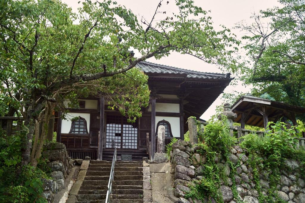 une petite maison avec des escaliers devant un immeuble dans l'établissement Yumura Onsen MIDORIYA, à Yumura