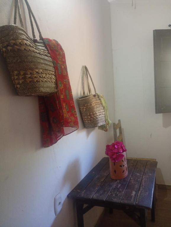 a wooden bench with three baskets on the wall at Quarto Pé na Areia in Ilhéus