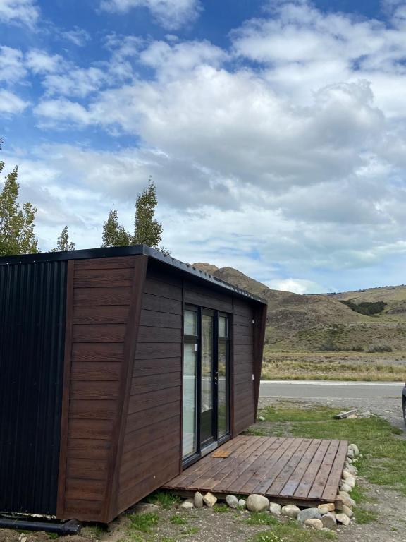 a small wooden cabin with a wooden deck at Terra Loft in El Chalten