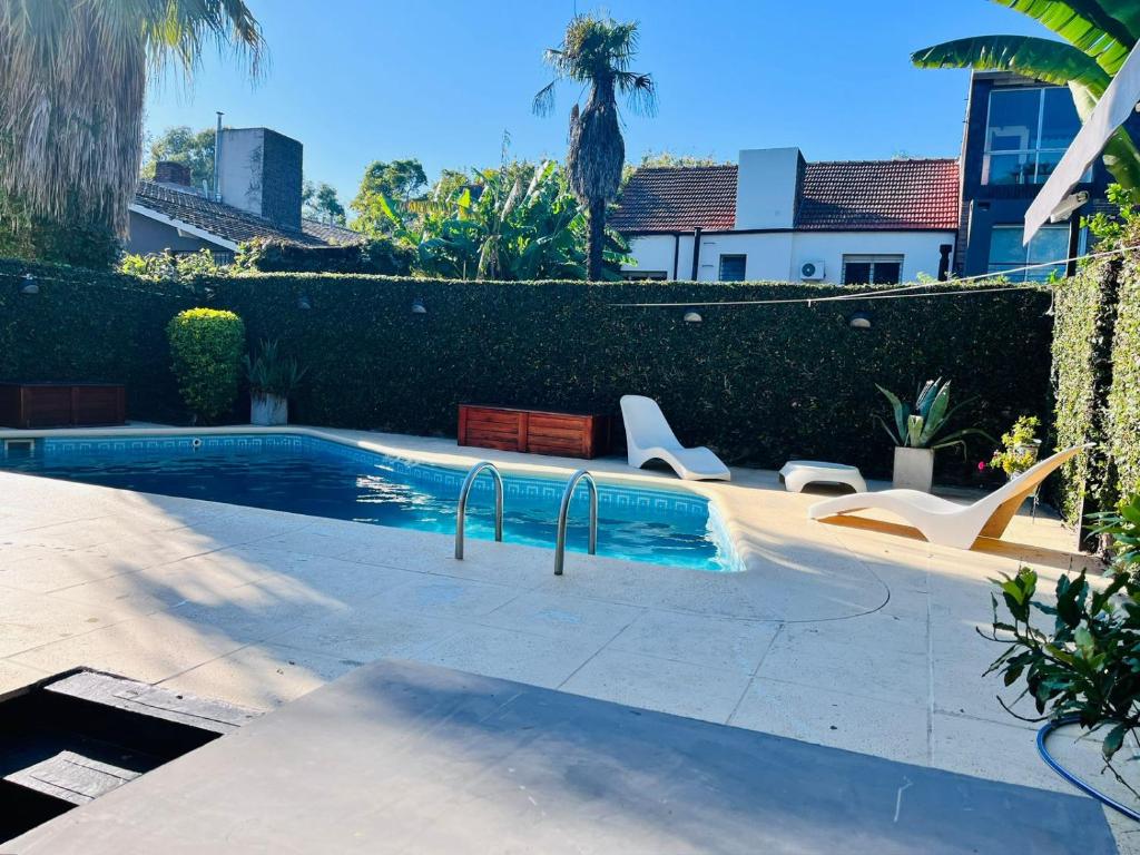 a swimming pool with chairs in a yard at Casa hermosa piscina con parrilla in Victoria