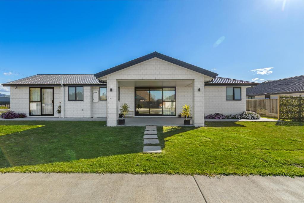 a house with a green lawn in front of it at Blenheim Accommodation in Blenheim