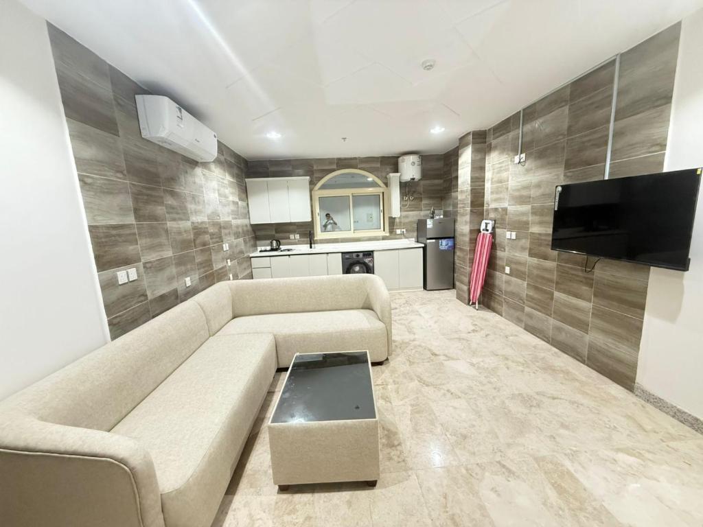 a living room with a couch and a flat screen tv at فندق ضيافة المدينة in Medina