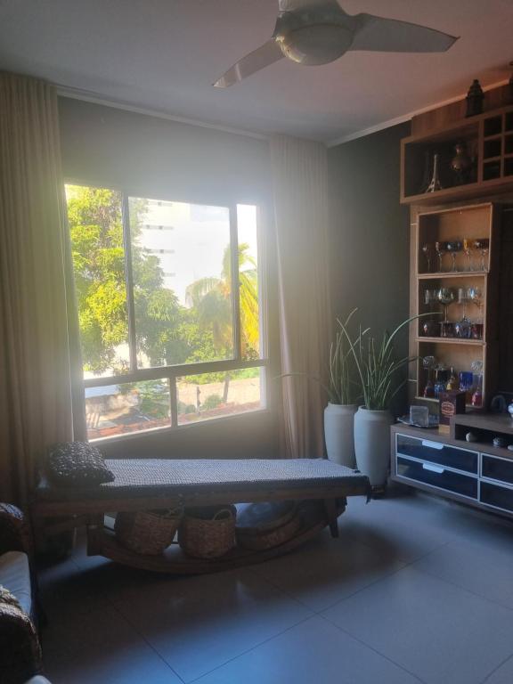 a living room with a window and a bench at Quarto casal privativo in Cuiabá