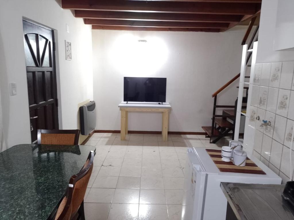 a living room with a television and a table with a television at El Refugio al Norte del Fin del Mundo A in Río Grande