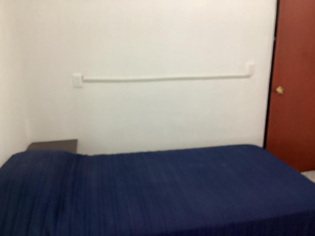 a bedroom with a blue bed and a white wall at Habitación privada zona Satélite in Mexico City