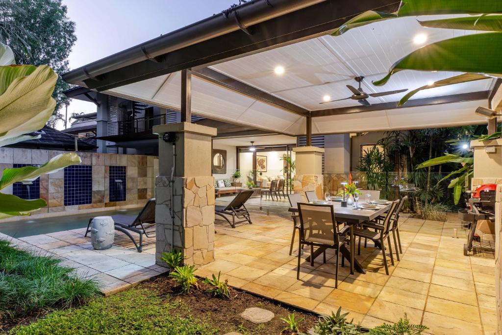 a patio with an umbrella and a table and chairs at SeaEden Port Douglas Apartments in Craiglie