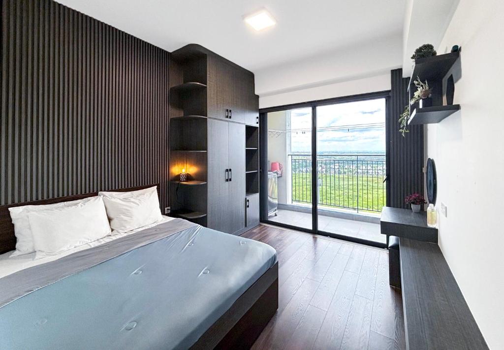 a bedroom with a large bed and a large window at Lumiere Apartment Swanbay in Nhơn Trạch