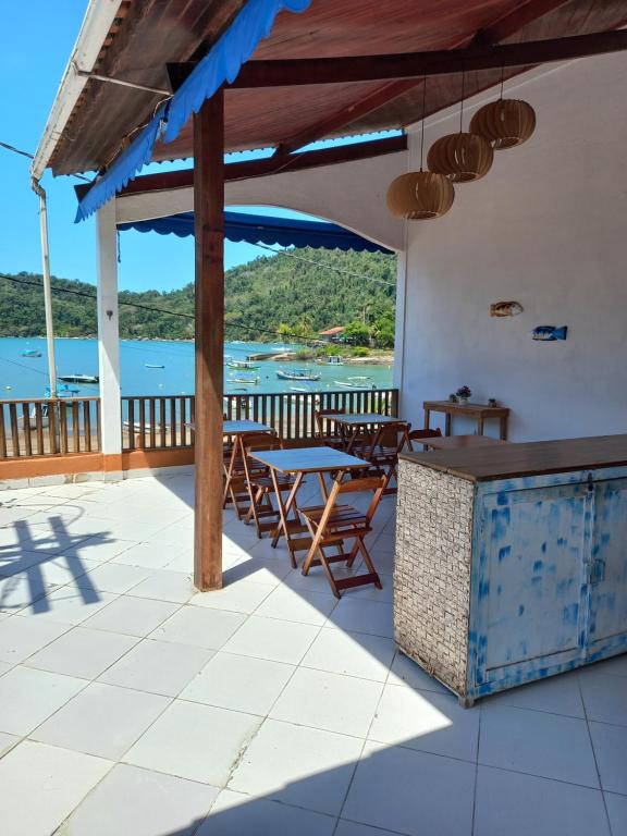 un patio con tavoli, sedie e vista sull'acqua di Pousada Verona Paraty a Parati