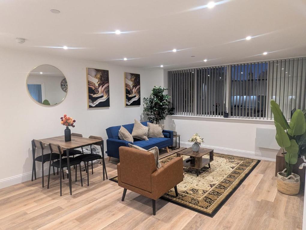 a living room with a blue couch and a table at Homely & Lush 1 Bed Apartment at Trinity Point Gravesend, Suitable for Long Stay and Short Stay in Gravesend
