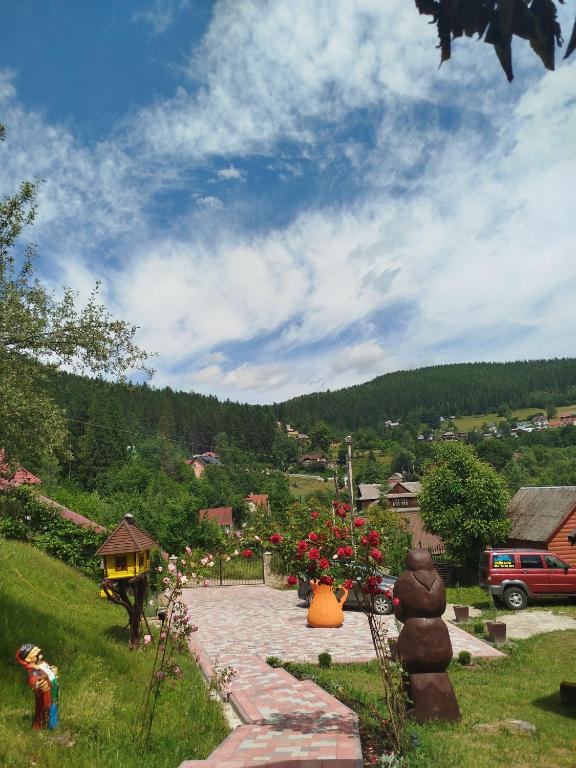 a garden with a stone walkway and flowers in a yard at Лісова казка in Yaremche