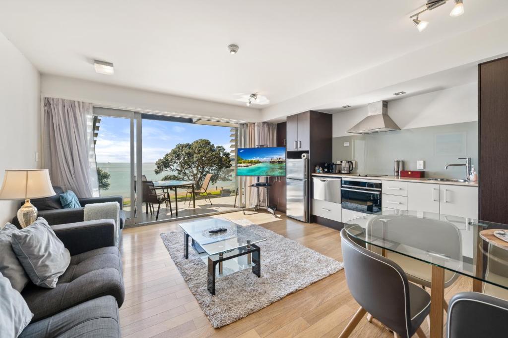 a living room with a couch and a table at Paihia Beachfront 1 Bedroom Aptm in Paihia