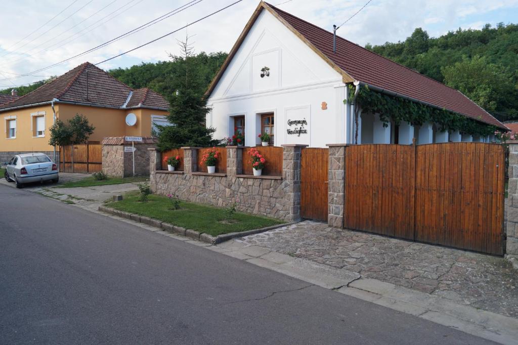 uma casa branca com uma cerca de madeira em Cseresznyés Vendégház em Szomolya