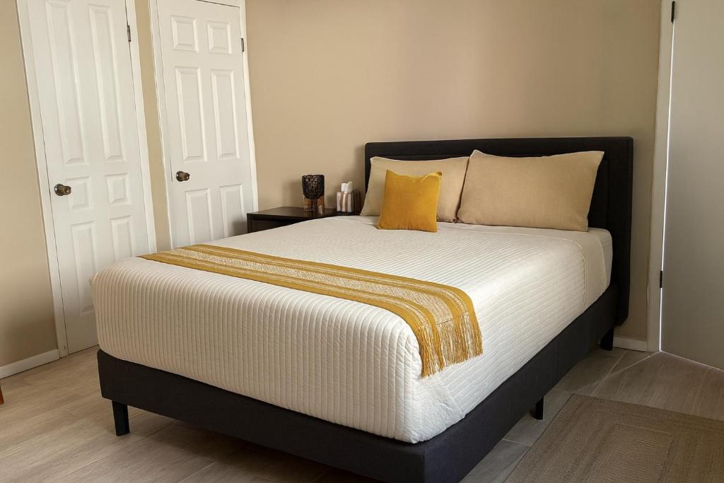a bedroom with a large bed with yellow pillows at Stellarium Hotel in Ensenada