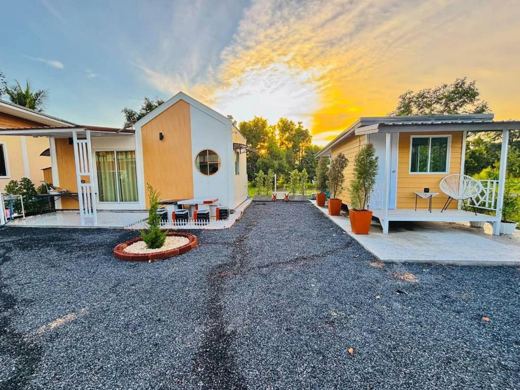 a house with a gravel driveway in front of it at RT House Resort in Ban Phawon