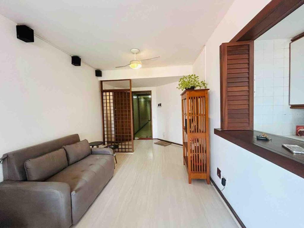 een woonkamer met een bank en een keuken bij Top 40 - Apartamento na Barra vista do mar e lagoa in Rio de Janeiro