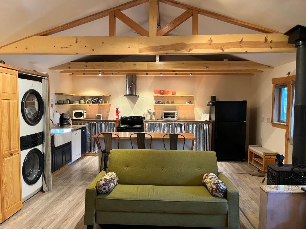 un soggiorno con un divano verde e una cucina di Still Point in the Woods ad Ashland