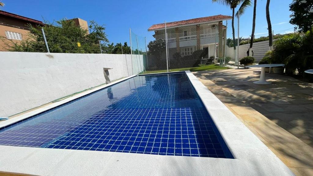 a swimming pool with blue tiles on the side of a house at Casa Beach park in Aquiraz