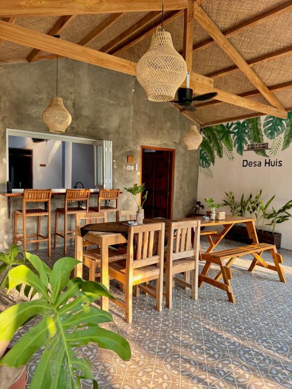 a dining room with wooden tables and chairs at Desa Huis Yogyakarta in Gandok