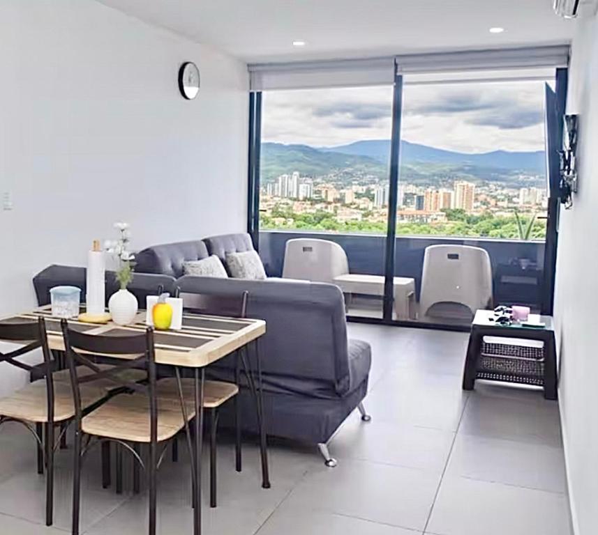 een woonkamer met een bank en een tafel met uitzicht bij Escalon apartment in San Salvador