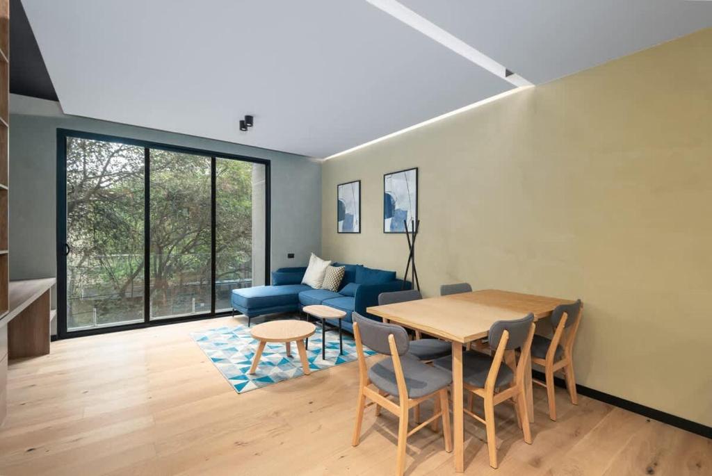 a living room with a table and a blue couch at ZKH Luxury Collection Roma Norte in Mexico City